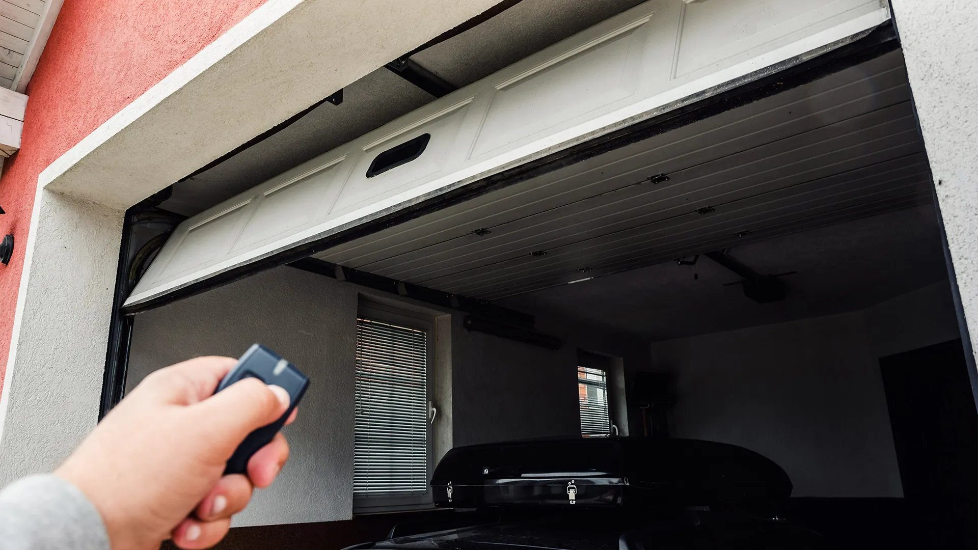 Person closing their automated garage door after parking car inside