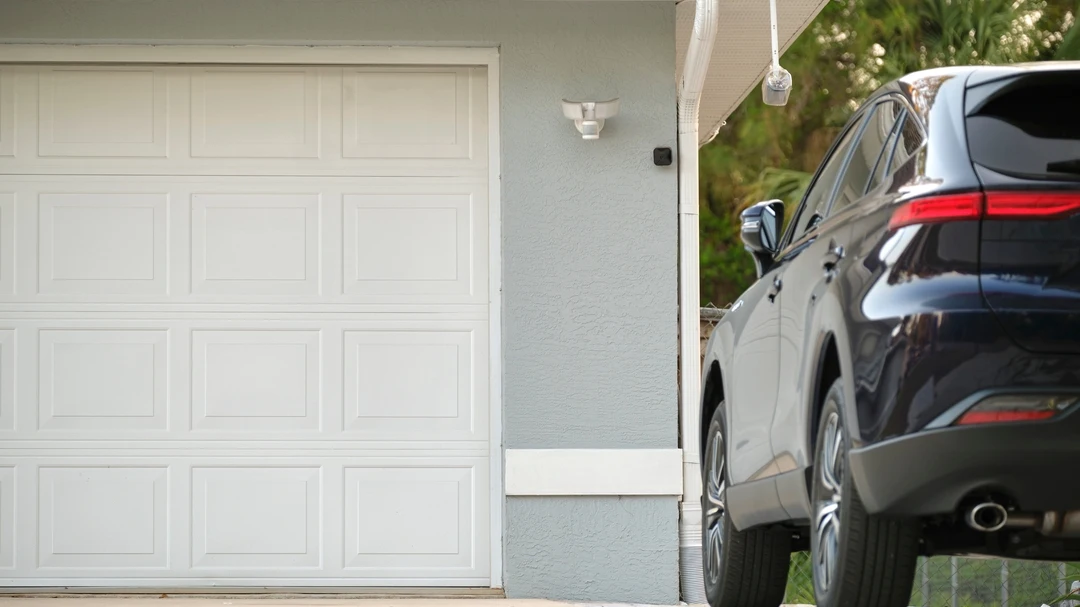 Black car in front of wooden garage