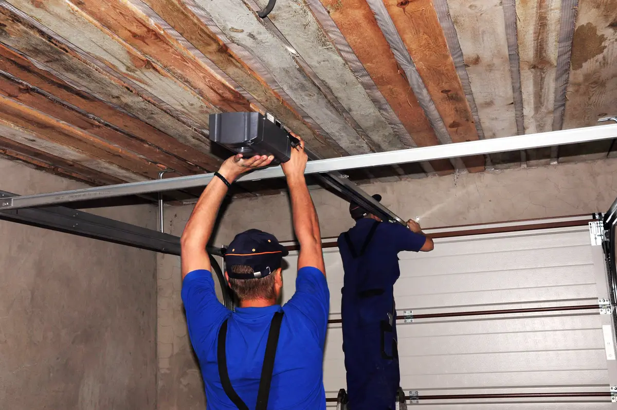Two men repairing a garage door