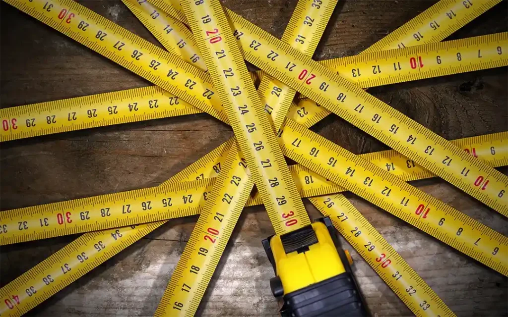 Yellow tape measure on wooden surface