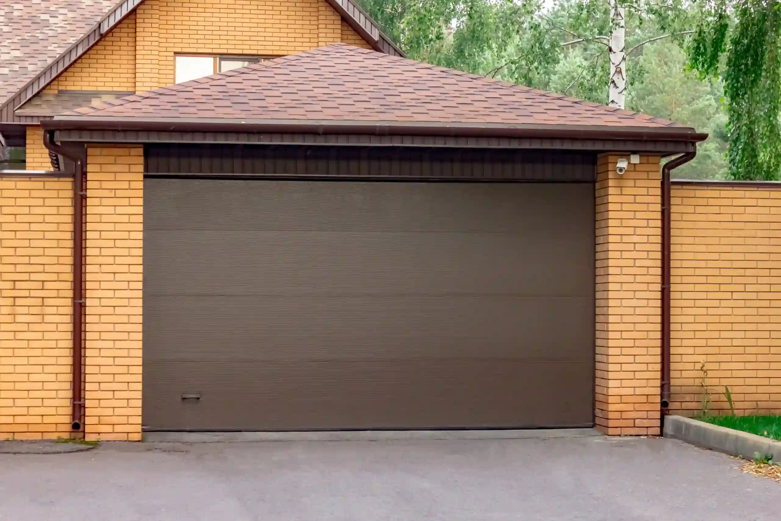 Face brick residential home with dark wood single garage doors