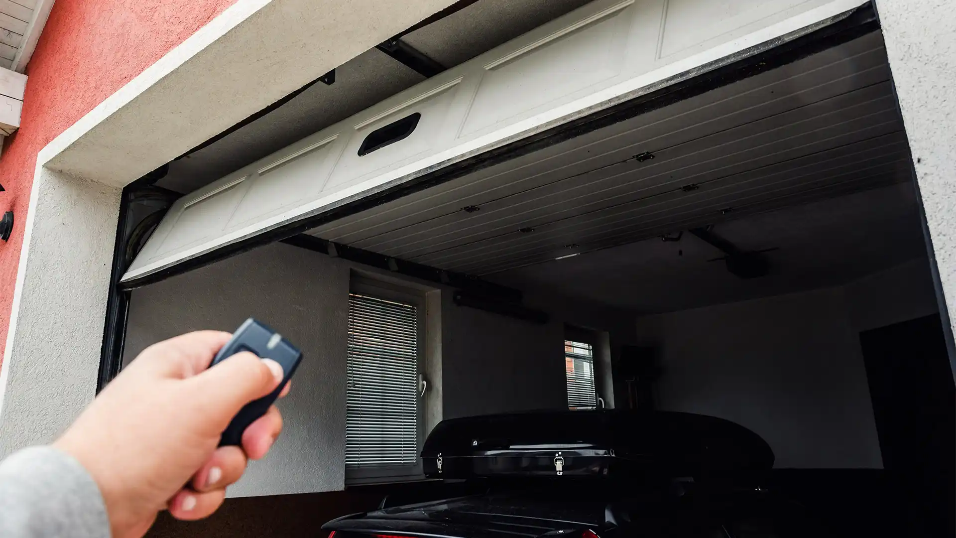 Person using remote controller to open and close garage door