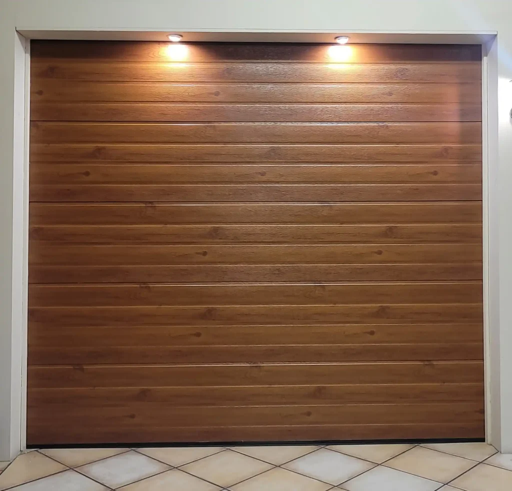 Sectional garage door with a woodlook steel finish in a horizontal slatted design.
