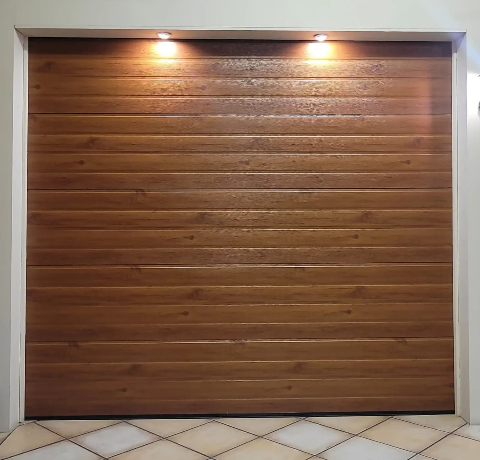 Sectional garage door with a woodlook steel finish in a horizontal slatted design.
